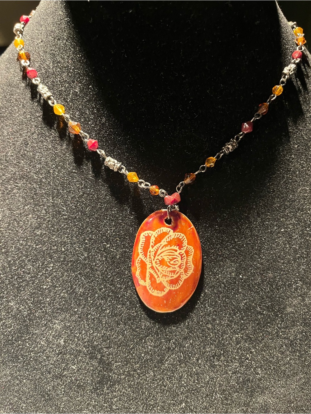 Carved rose motif on a beaded necklace. Necklace measures 18” plus 3” extender.